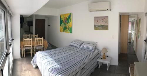 1 dormitorio con 1 cama con manta de rayas azul y blanco en Departamento - Studio en Palermo Soho en Buenos Aires