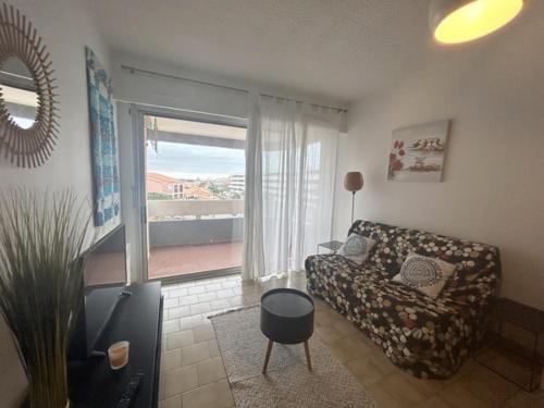 a living room with a couch and a window at appartement 4 pers 50 m plage 4B237 in Le Barcarès