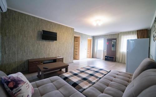 a living room with a couch and a tv at Райский Дворик in Pogreby