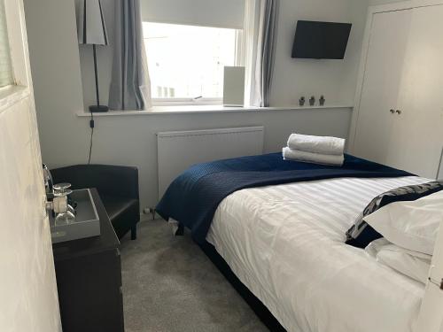 1 dormitorio con 1 cama con manta azul y ventana en Little Limetree, en Moffat