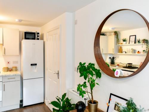 a kitchen with a white refrigerator and a mirror at Pass the Keys Cosy 2 Bedroom Apartment in Barry with Parking in Barry