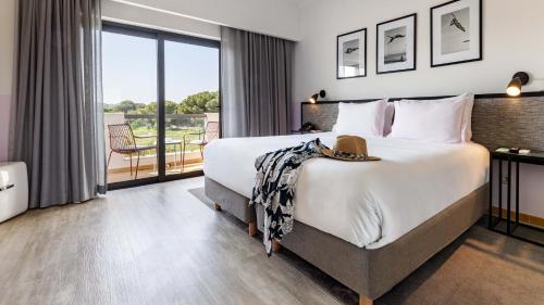 a bedroom with a large bed and a balcony at The Magnolia Hotel in Quinta do Lago