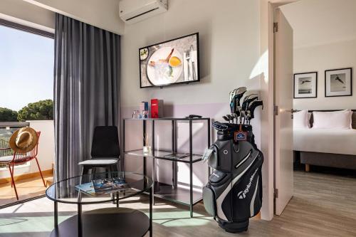 a room with a room with a bed and a table at The Magnolia Hotel in Quinta do Lago