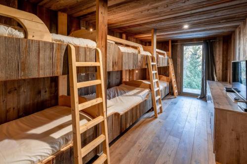 ペイゼ・ナンクロワにあるMasara - 5-room chalet plus sauna and jacuzzi 12 pのキャビン内の二段ベッド4台が備わる客室です。