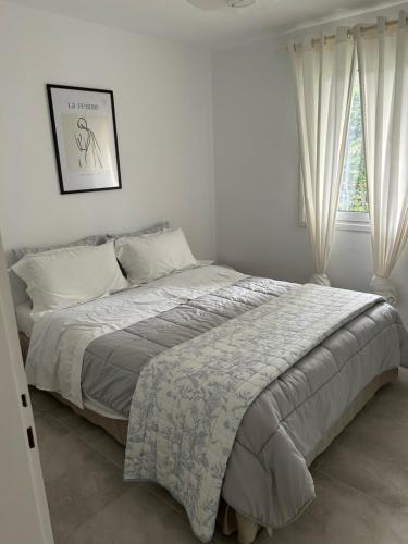 a bed in a white bedroom with a window at Zeusplace Seaside Home private beach and parking in Plaka Litochorou