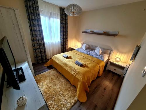 a bedroom with a bed with a yellow bedspread at BástyaVár Családi Apartmanház - Gyula in Gyula
