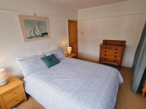 ein kleines Schlafzimmer mit einem Bett und einer Kommode in der Unterkunft Pass the Keys Cheerful 2 bed home with garden near Exeter centre in Exeter