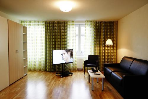 TV in/ali zabaviščno središče v nastanitvi Residence Apartments by Hotel du Commerce