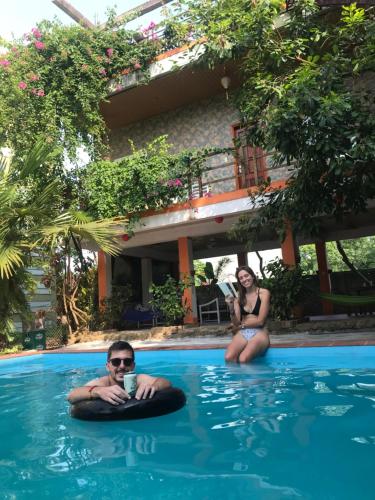 two people sitting on inflatables in a swimming pool at Phong Nha Dawn Home in Phong Nha