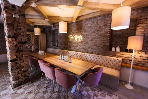 une salle à manger avec une table en bois et des chaises violettes dans l'établissement The Berg's 3, à Ocna-Mureşului