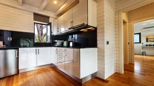a kitchen with white cabinets and a wooden floor at The Magnolia Hotel in Quinta do Lago