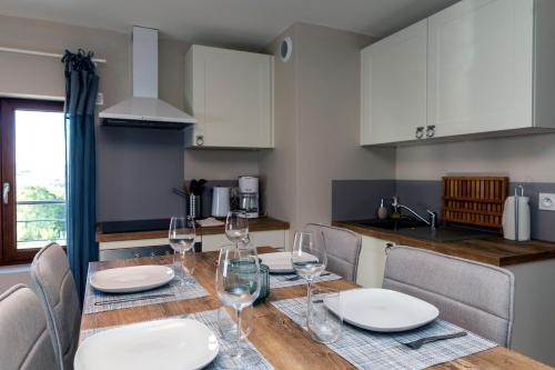 a kitchen with a dining table with wine glasses at T2 Meublé de 40m2 axe Annecy/Geneve in Saint-Martin-Bellevue