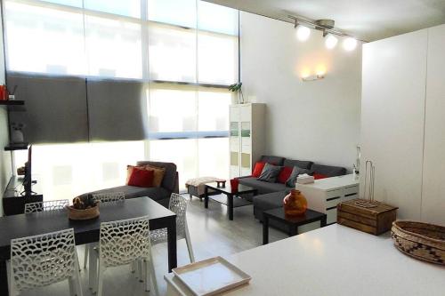 ein Wohnzimmer mit einem Sofa und einem Tisch in der Unterkunft Fantástico Loft de Diseño en Alcalá de Henares - Madrid in Alcalá de Henares