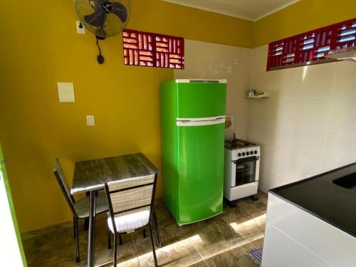 科魯里皮的住宿－Chalé Lagoa do Pau，带桌子的厨房内的绿色冰箱