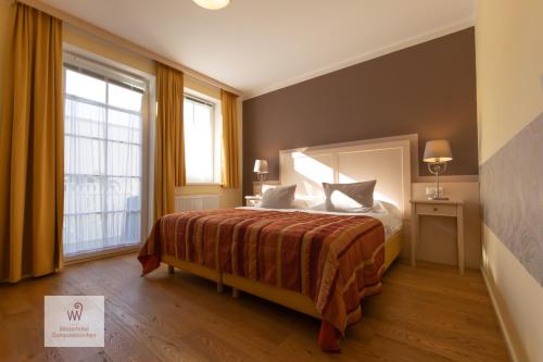 a hotel room with a bed and a large window at Winzerhotel Gumpoldskirchen in Gumpoldskirchen