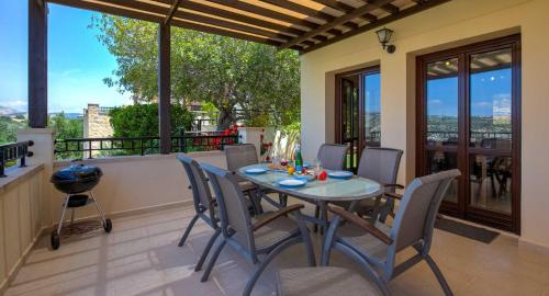 a dining room with a table and chairs on a balcony at Fantastic Junior Villa CZ02 Salamis with Gorgeous Views, Aphrodite Hills in Kouklia