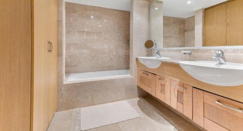 a bathroom with a sink and a tub and a mirror at Fantastic Junior Villa CZ02 Salamis with Gorgeous Views, Aphrodite Hills in Kouklia