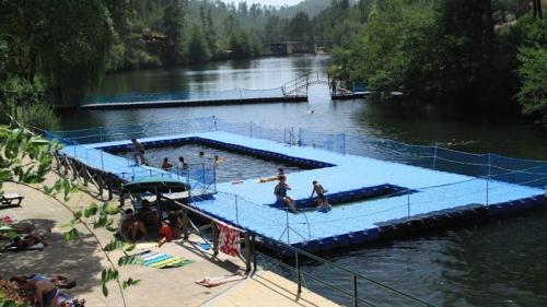 - une piscine dans une rivière avec des gens dans l'établissement Casa Xara, à Proença-a-Nova