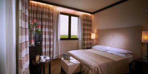 a hotel room with a bed and a window at Hotel Pisa Valdera in Pontedera