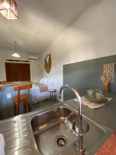 a kitchen with a sink and a bed in a room at Lá na Chay Caraíva Refúgio tranquilo & experiência local in Caraíva