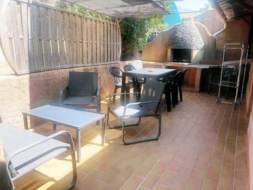 un patio avec des tables, des chaises et un grill dans l'établissement T3 Zini, à Appietto