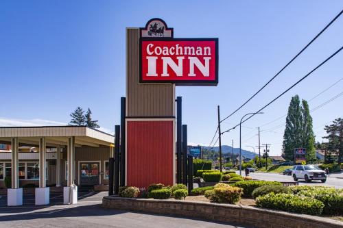 a sign for a cadiannian inn on a street at Coachman Inn in Bellingham