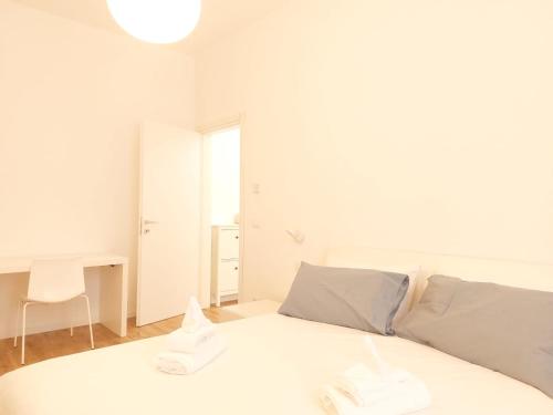 a white bedroom with a white bed and a desk at Apartment Ca' de Bezzi in Bolzano