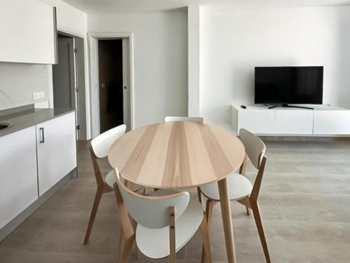 a dining room with a wooden table and chairs at La casita de Gara in Caleta de Sebo