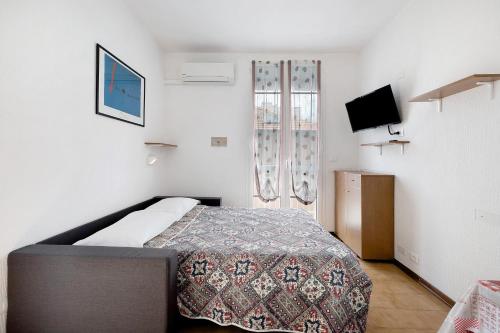 a small bedroom with a bed and a tv at Monolocale 9 in Borgio Verezzi