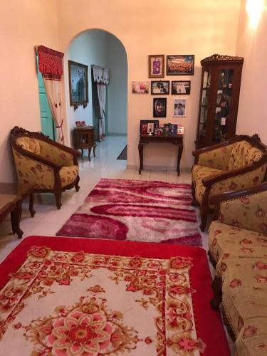 a living room with two couches and a rug at Hajjah Homestay Muar in Muar