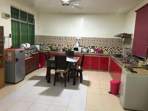 a kitchen with a table and chairs in it at Hajjah Homestay Muar in Muar
