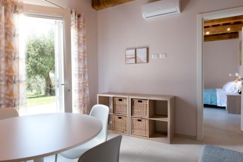 ein weißes Esszimmer mit einem Tisch und Stühlen in der Unterkunft Podere n.8 Bio Casale Maremma in Alberese