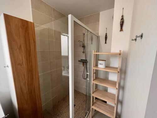 La salle de bains est pourvue d'une douche et d'une porte en verre. dans l'établissement la villa d'Irissou YourHostHelper, à Andernos-les-Bains