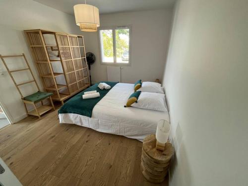 une chambre avec un grand lit dans une pièce dans l'établissement la villa d'Irissou, à Andernos-les-Bains