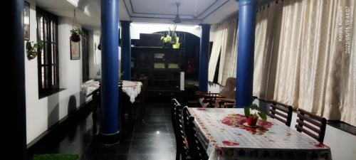 a dining room with two tables and blue columns at Annie's Villa in Kovalam