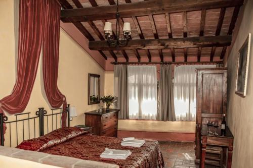 um quarto com uma cama, uma cómoda e janelas em Fattoria Guicciardini em San Gimignano