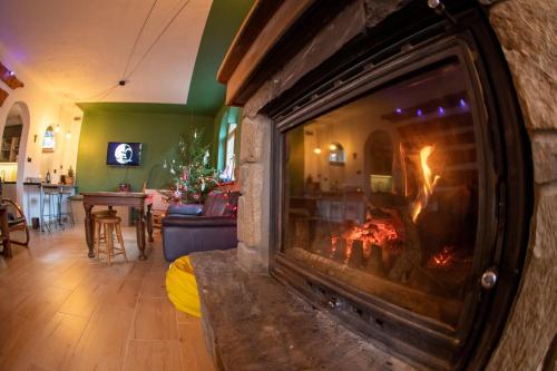 a fireplace in a living room with a fire in it at Poza Horyzont in Korbielów