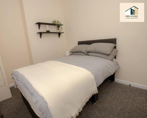a bedroom with a bed and a shelf on the wall at Three Modern Double Bed Apartment By NBH Living Short Lets & Serviced Accommodation in Brighton & Hove