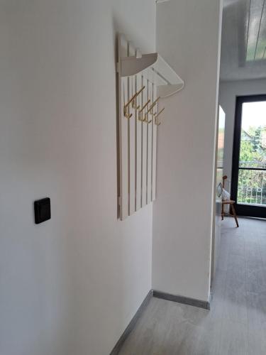 a hallway with a white wall with a chandelier at Apartment Oase in Balatonszemes