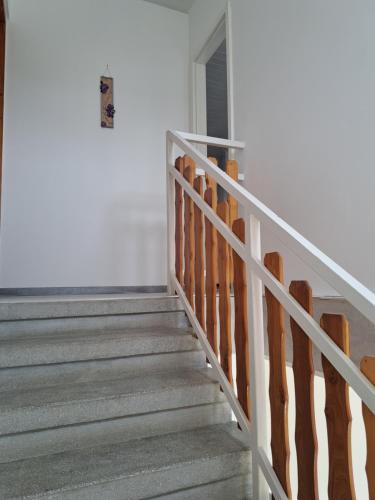 a staircase in a home with white walls and wooden railings at Apartment Oase in Balatonszemes