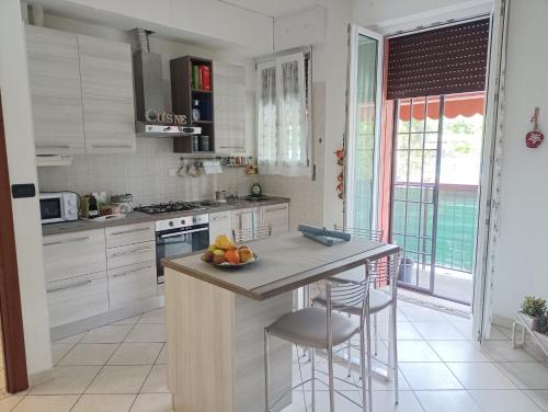 a kitchen with white cabinets and a island with bar stools at Sisters Home in Bologna