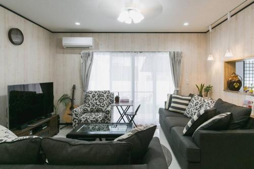 a living room with a couch and a tv at Vacation House Jo in Agarii