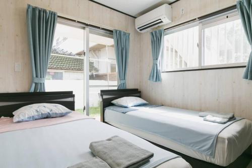 two beds in a room with a window at Vacation House Jo in Agarii