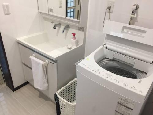 a washing machine in a bathroom with a sink at Vacation House Jo in Agarii