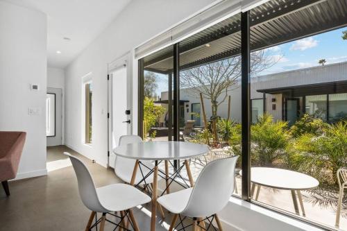 a dining room with white chairs and tables and large windows at Modern 1-bedroom Apartment - 80 Walkscore! in Phoenix
