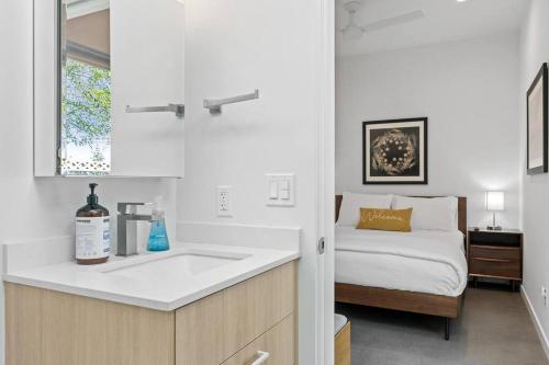 eine weiße Küche mit einem Waschbecken und einem Bett in der Unterkunft Modern 1-bedroom Apartment - 80 Walkscore! in Phoenix