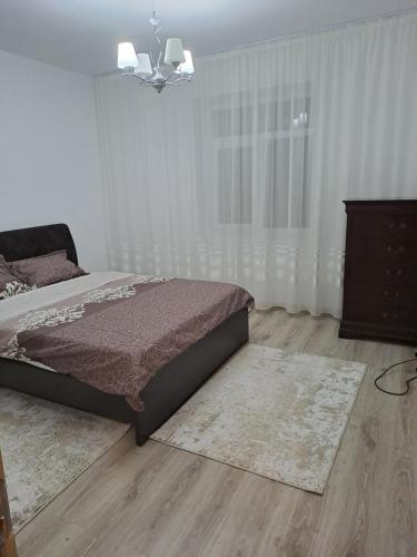a bedroom with a bed and a wooden floor at Casa Dragos in Basarabi