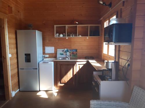 a kitchen with a refrigerator and a sink at Chalet des Remparts in Sainte-Marie