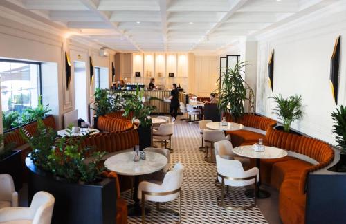 a restaurant with tables and chairs and people in the background at The Berg's 4 in Ocna-Mureşului