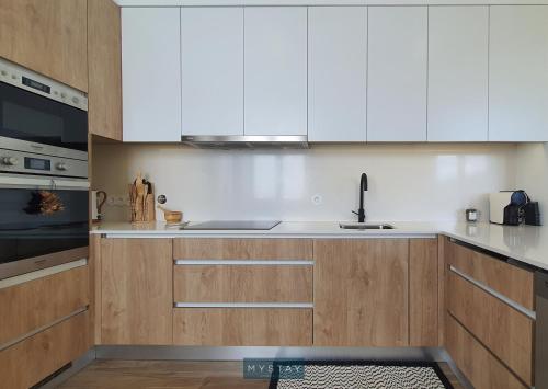 a kitchen with white cabinets and a sink at Casal Magister in Pedraça